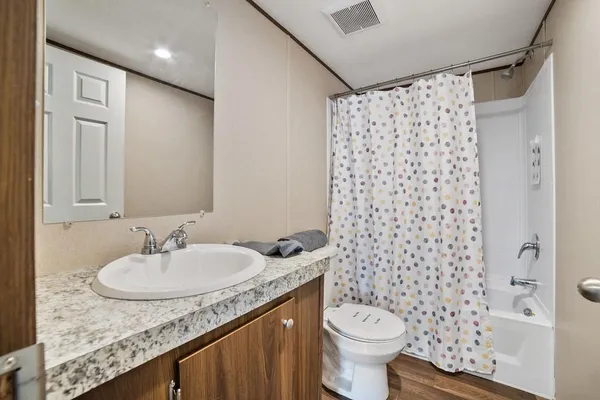 a bathroom with a granite countertop sink toilet and shower