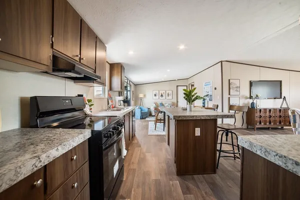 a kitchen with stainless steel appliances granite countertop a sink stove and refrigerator