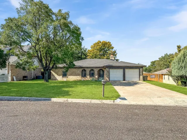 a front view of house with yard and trees