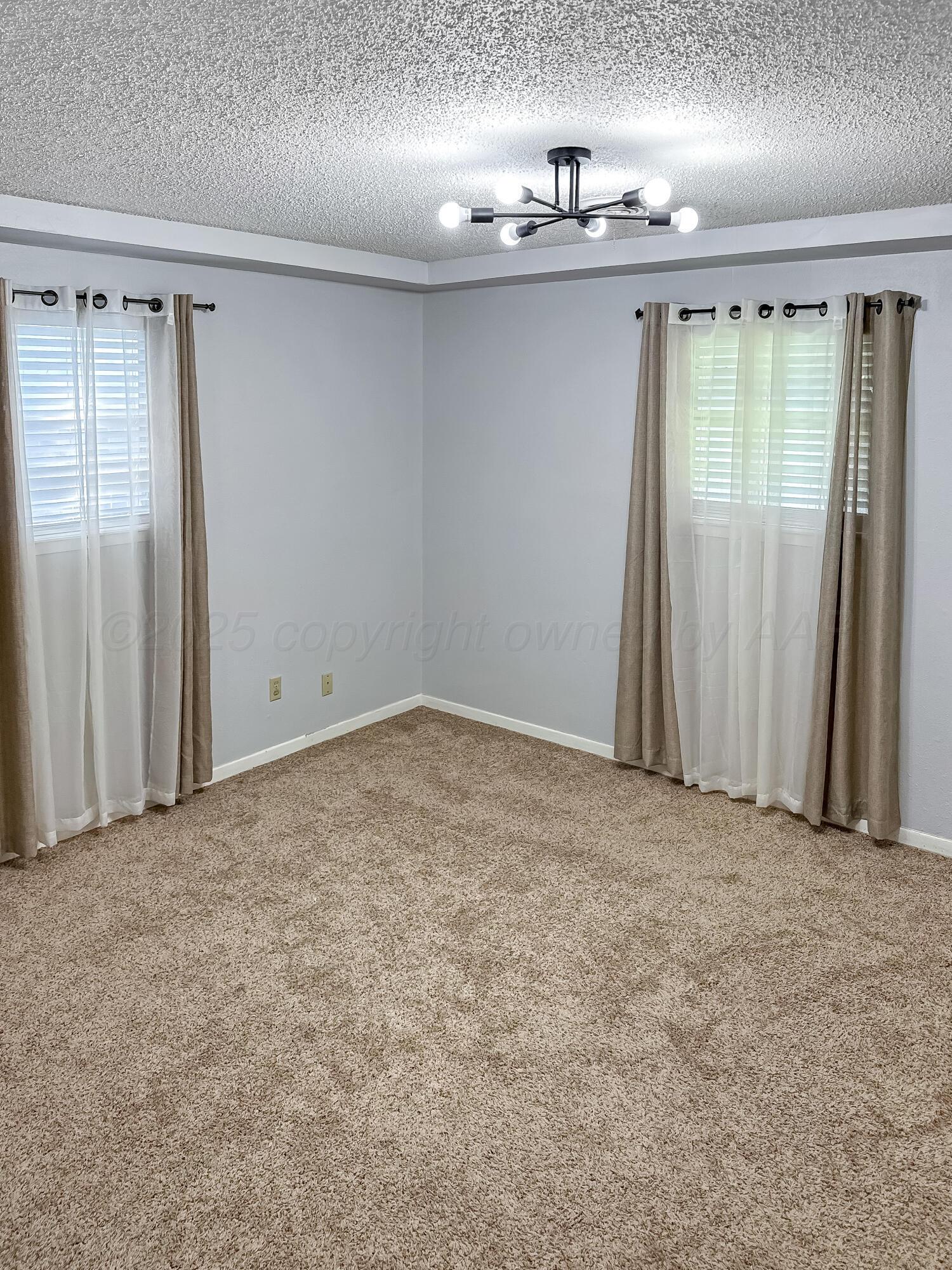 216 Skycrest Street Borger, TX 79007 - Photo 12 of 20 an empty room with kitchen view and natural light