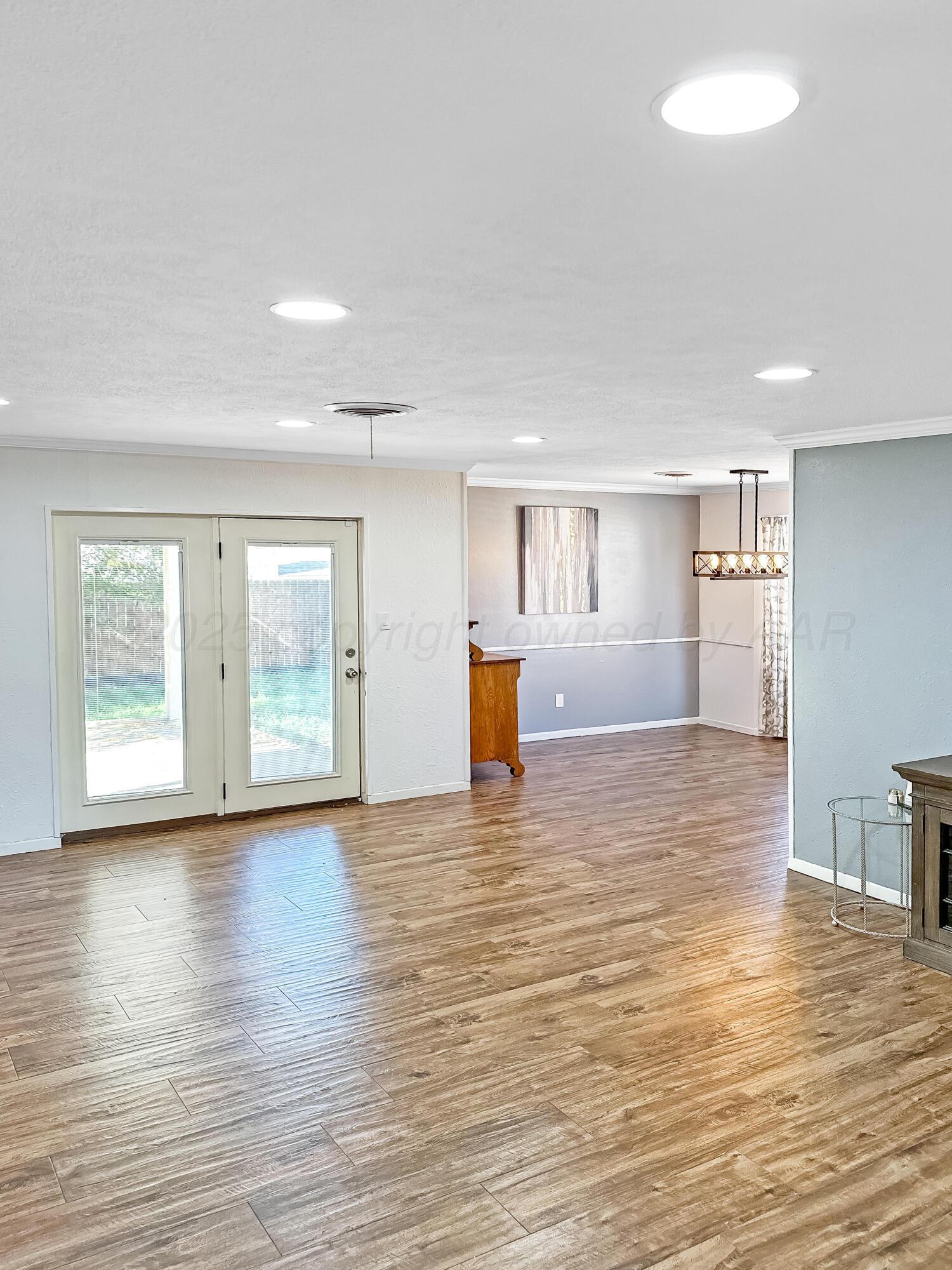 216 Skycrest Street Borger, TX 79007 - Photo 4 of 20 a view of empty room with wooden floor and windows