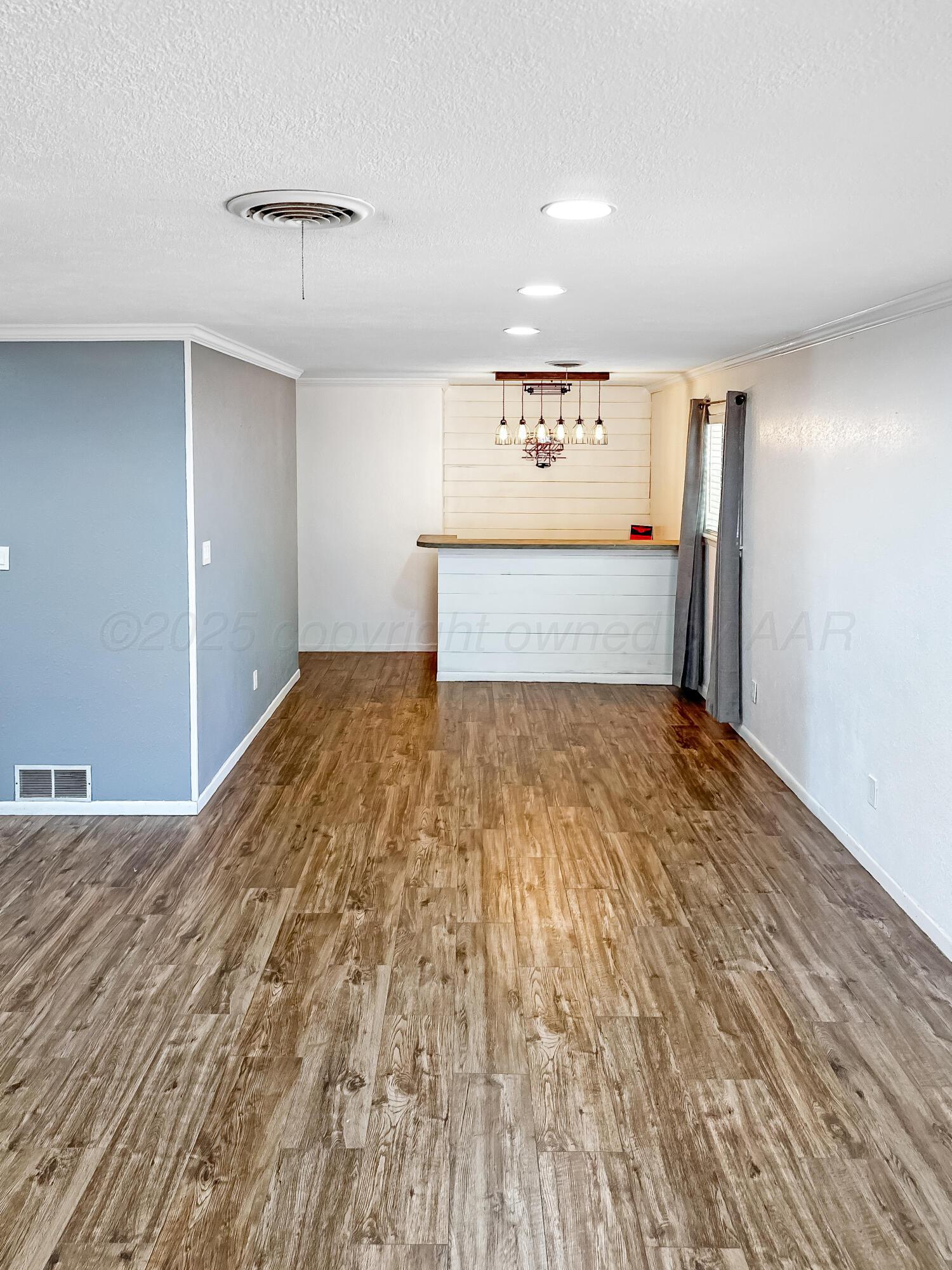 216 Skycrest Street Borger, TX 79007 - Photo 7 of 20 a view of empty room with wooden floor