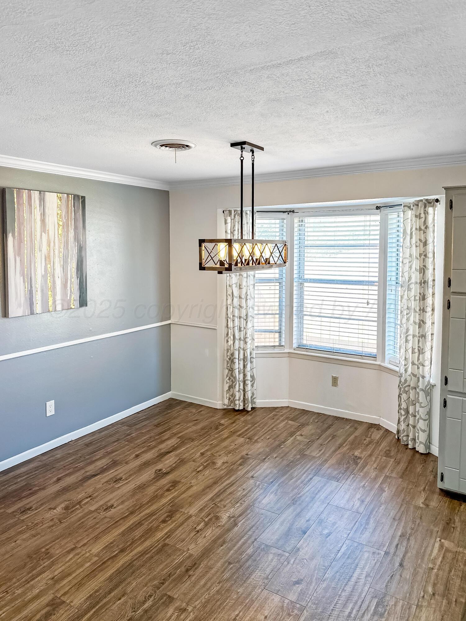216 Skycrest Street Borger, TX 79007 - Photo 8 of 20 a view of empty room with wooden floor and fan