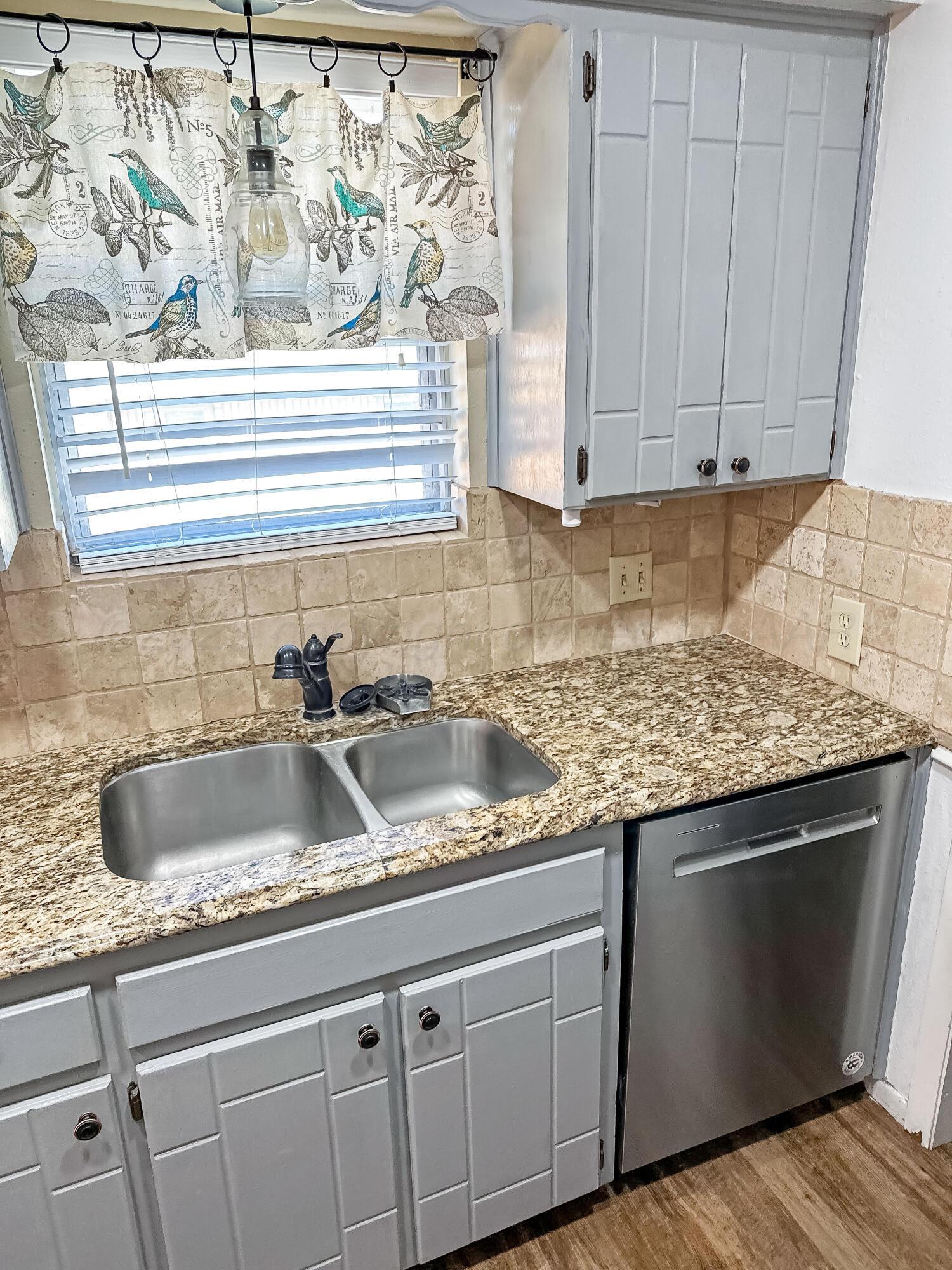 216 Skycrest Street Borger, TX 79007 - Photo 9 of 20 a kitchen with granite countertop a sink and a white cabinets