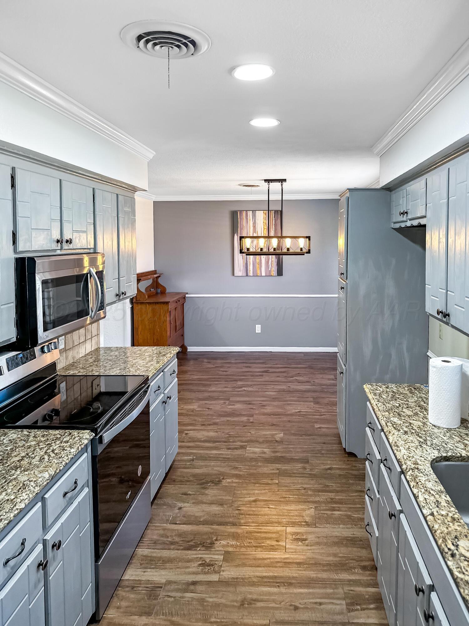 216 Skycrest Street Borger, TX 79007 - Photo 10 of 20 a kitchen with stainless steel appliances granite countertop a stove and a refrigerator