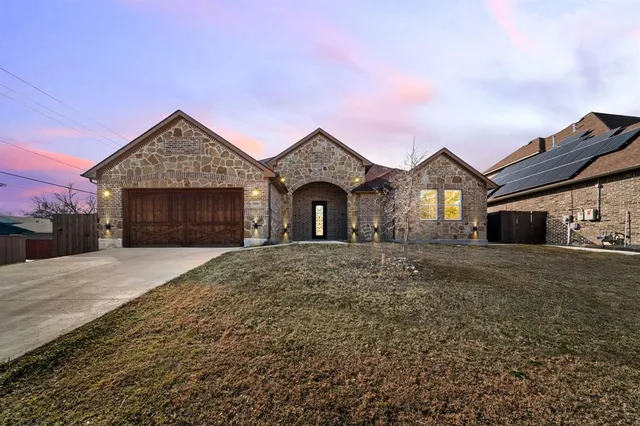 a front view of a house with a yard and garage