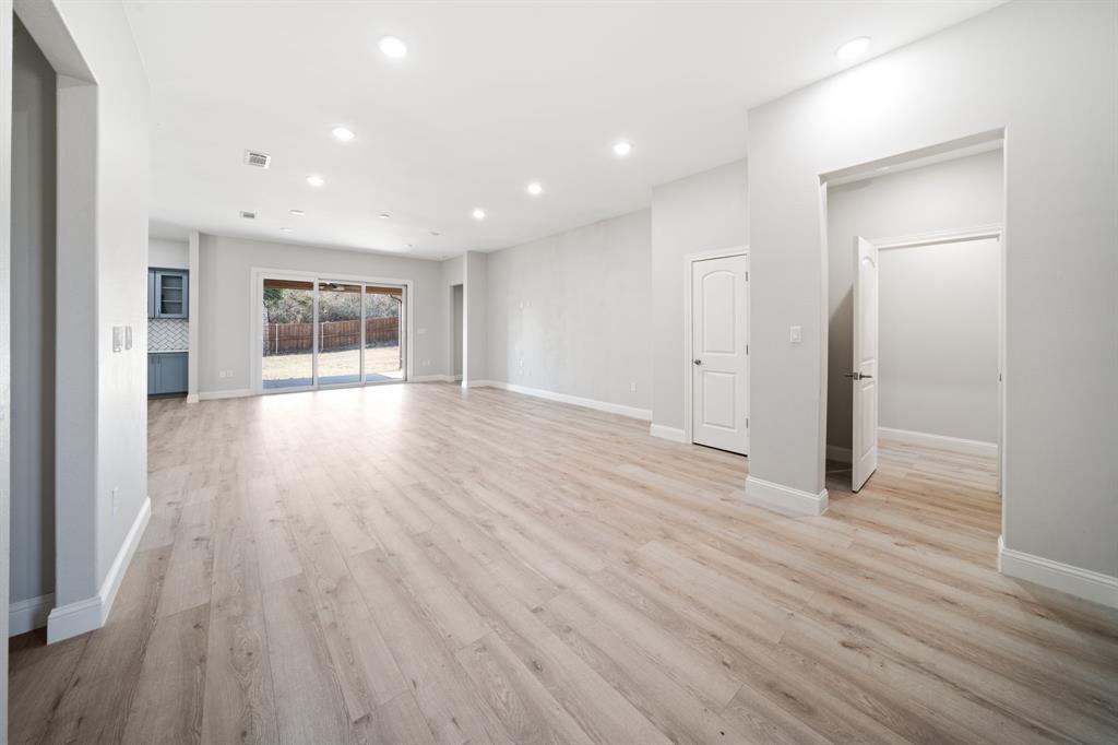 8809 Isom Lane Dallas, TX 75249 - Photo 11 of 40 an empty room with wooden floor and windows