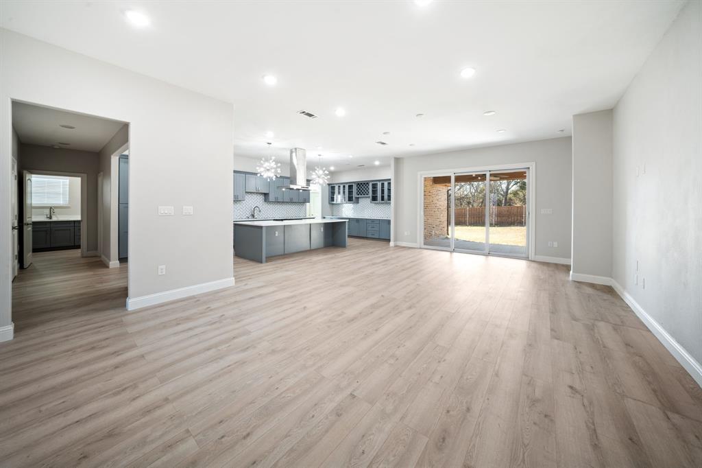 8809 Isom Lane Dallas, TX 75249 - Photo 12 of 40 an empty room with wooden floor and windows