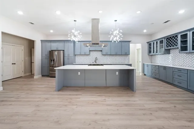 a large kitchen with kitchen island a sink stainless steel appliances and cabinets