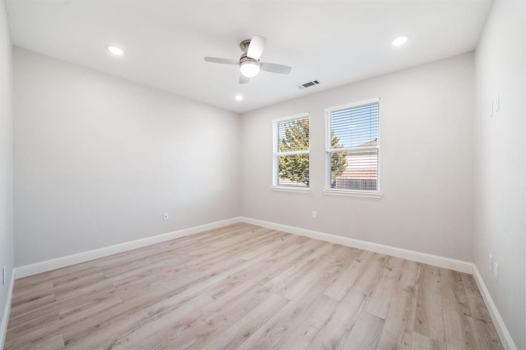 8809 Isom Lane Dallas, TX 75249 - Photo 24 of 40 an empty room with wooden floor and windows