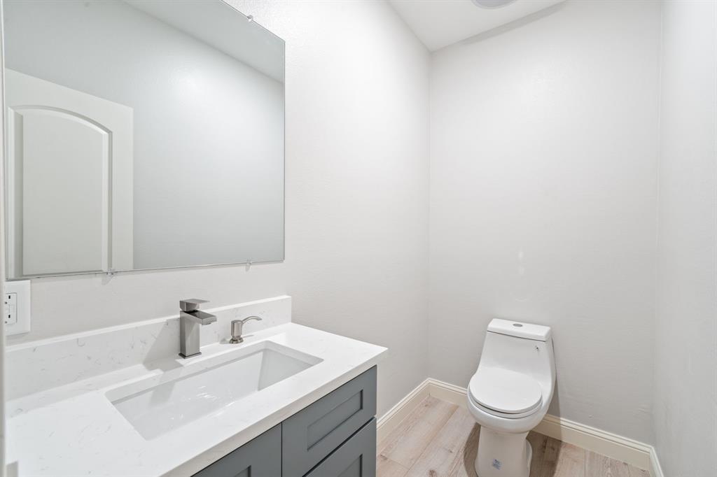 8809 Isom Lane Dallas, TX 75249 - Photo 29 of 40 a bathroom with a sink a toilet and mirror
