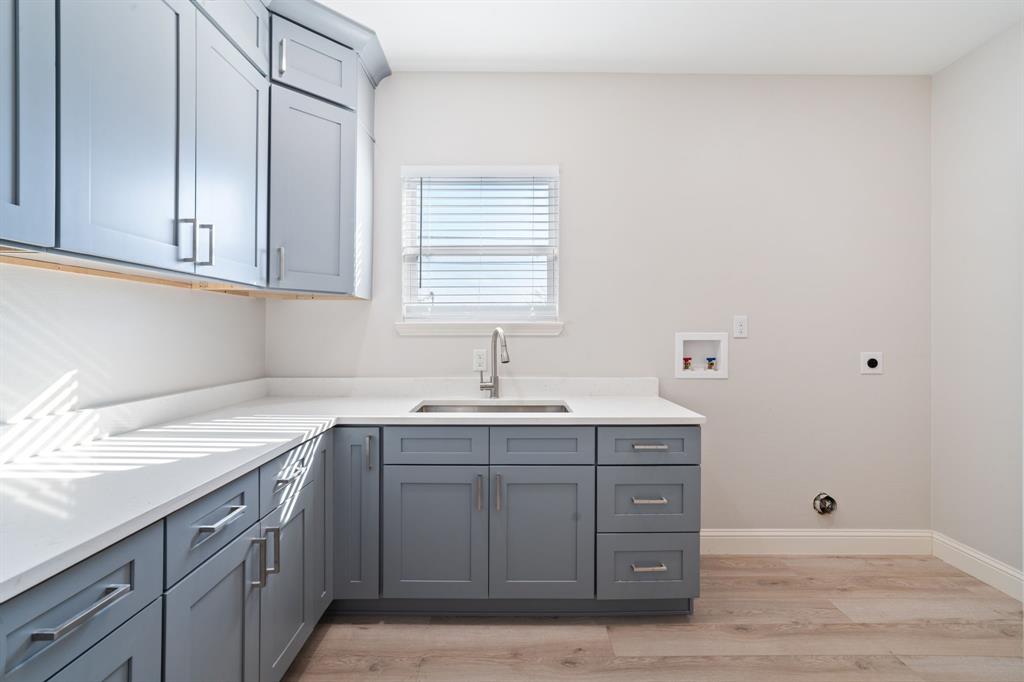 8809 Isom Lane Dallas, TX 75249 - Photo 30 of 40 a kitchen with a sink cabinets and a window