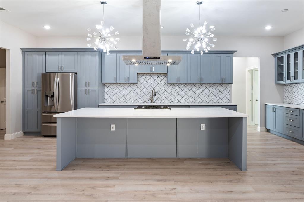 8809 Isom Lane Dallas, TX 75249 - Photo 3 of 40 a large kitchen with granite countertop a refrigerator and a chandelier
