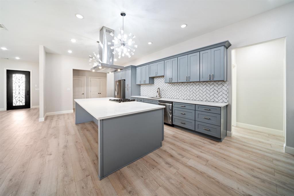 8809 Isom Lane Dallas, TX 75249 - Photo 5 of 40 a kitchen with a sink cabinets and wooden floor