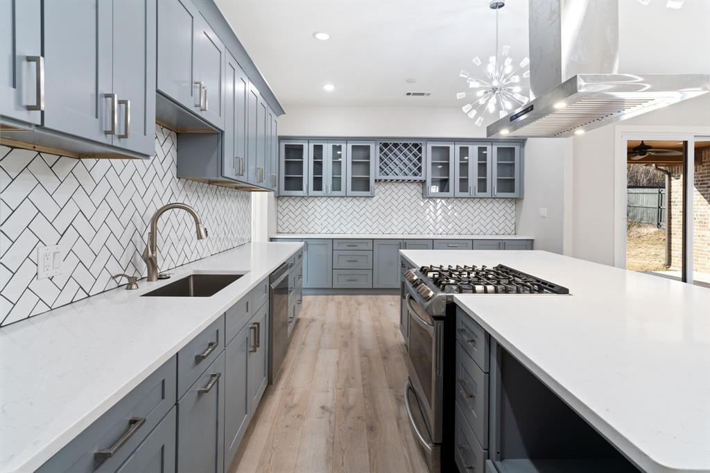 8809 Isom Lane Dallas, TX 75249 - Photo 7 of 40 a kitchen with kitchen island a sink appliances and cabinets