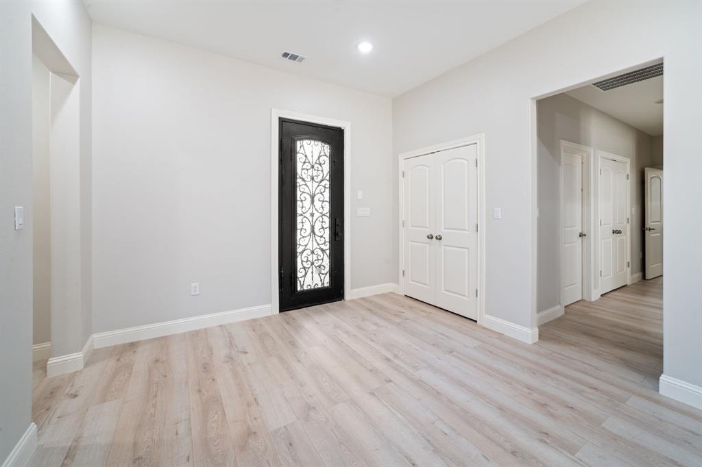 8809 Isom Lane Dallas, TX 75249 - Photo 9 of 40 a view of an empty room with wooden floor and a window