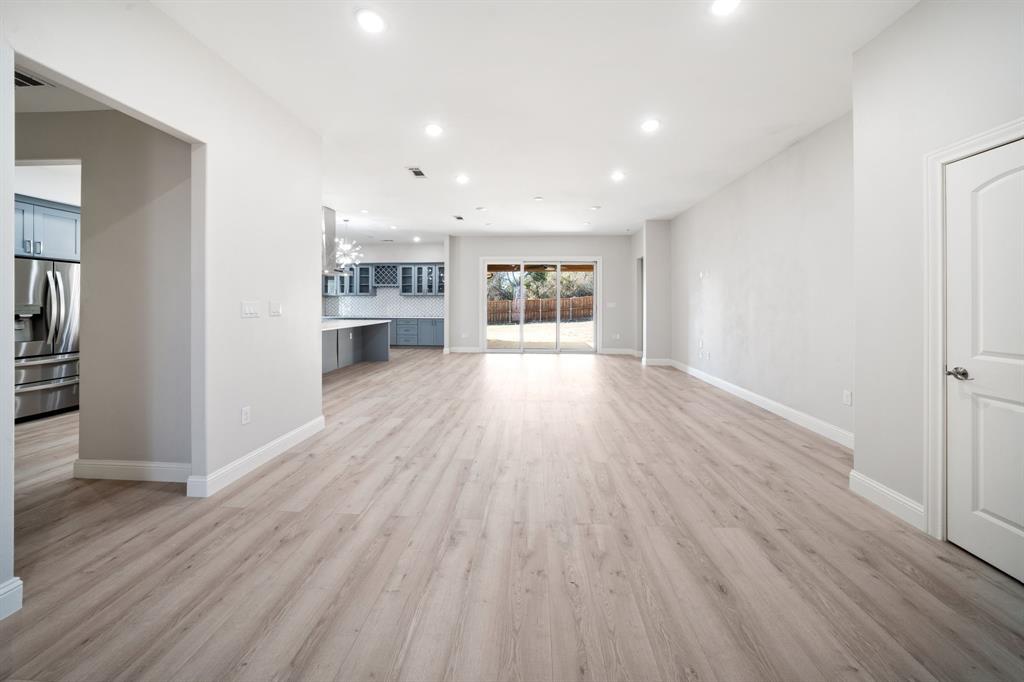 8809 Isom Lane Dallas, TX 75249 - Photo 10 of 40 wooden floor in an empty room with a kitchen