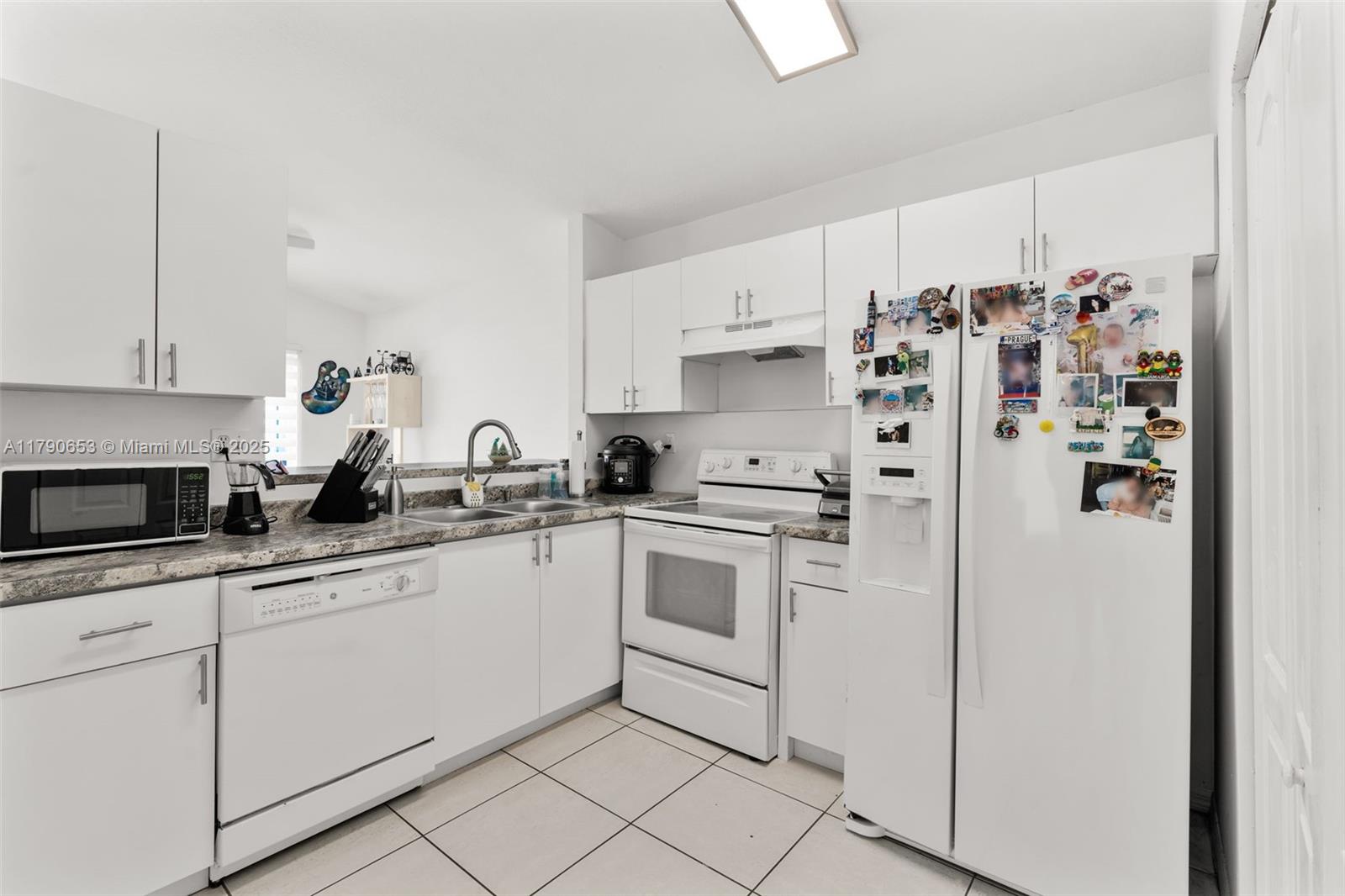 17834 Southwest 144th Court Miami, FL 33177 - Photo 19 of 23 a kitchen with white cabinets and white appliances