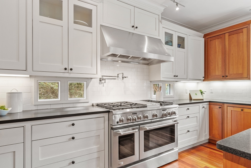 168 Nashawtuc Road Concord, MA 01742 - Photo 6 of 42 a kitchen with stainless steel appliances granite countertop white cabinets and a stove a oven with wooden floors