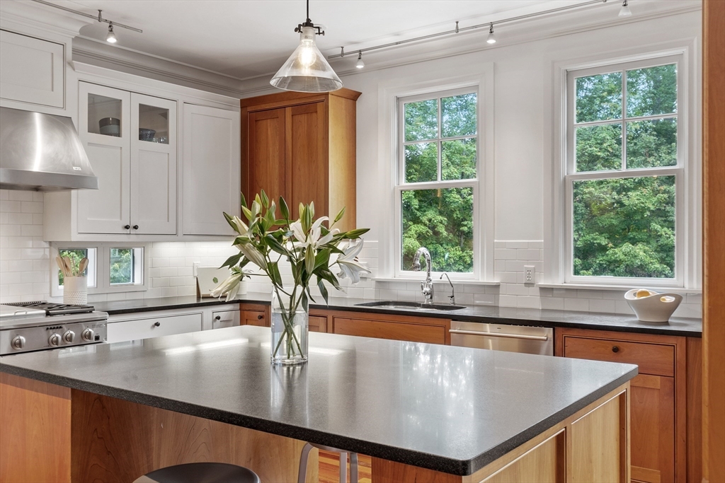 168 Nashawtuc Road Concord, MA 01742 - Photo 7 of 42 a kitchen with stainless steel appliances granite countertop a sink a counter space and windows