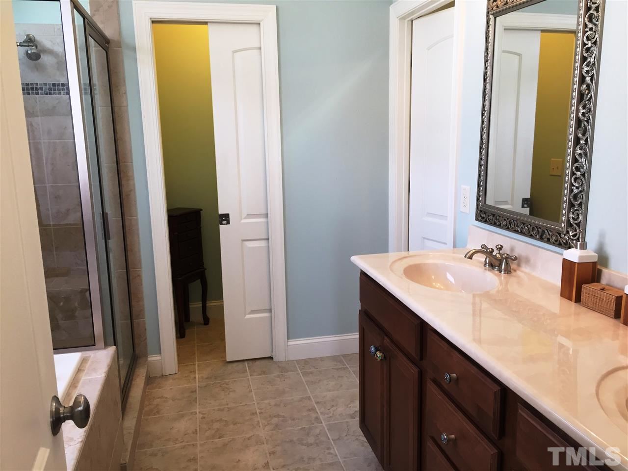 1307 Ileagnes Road Raleigh, NC 27603 - Photo 17 of 24 Master bath features a raised height double vanity, tile floors, a private lavatory room with pocket door, and a large walk-in closet.