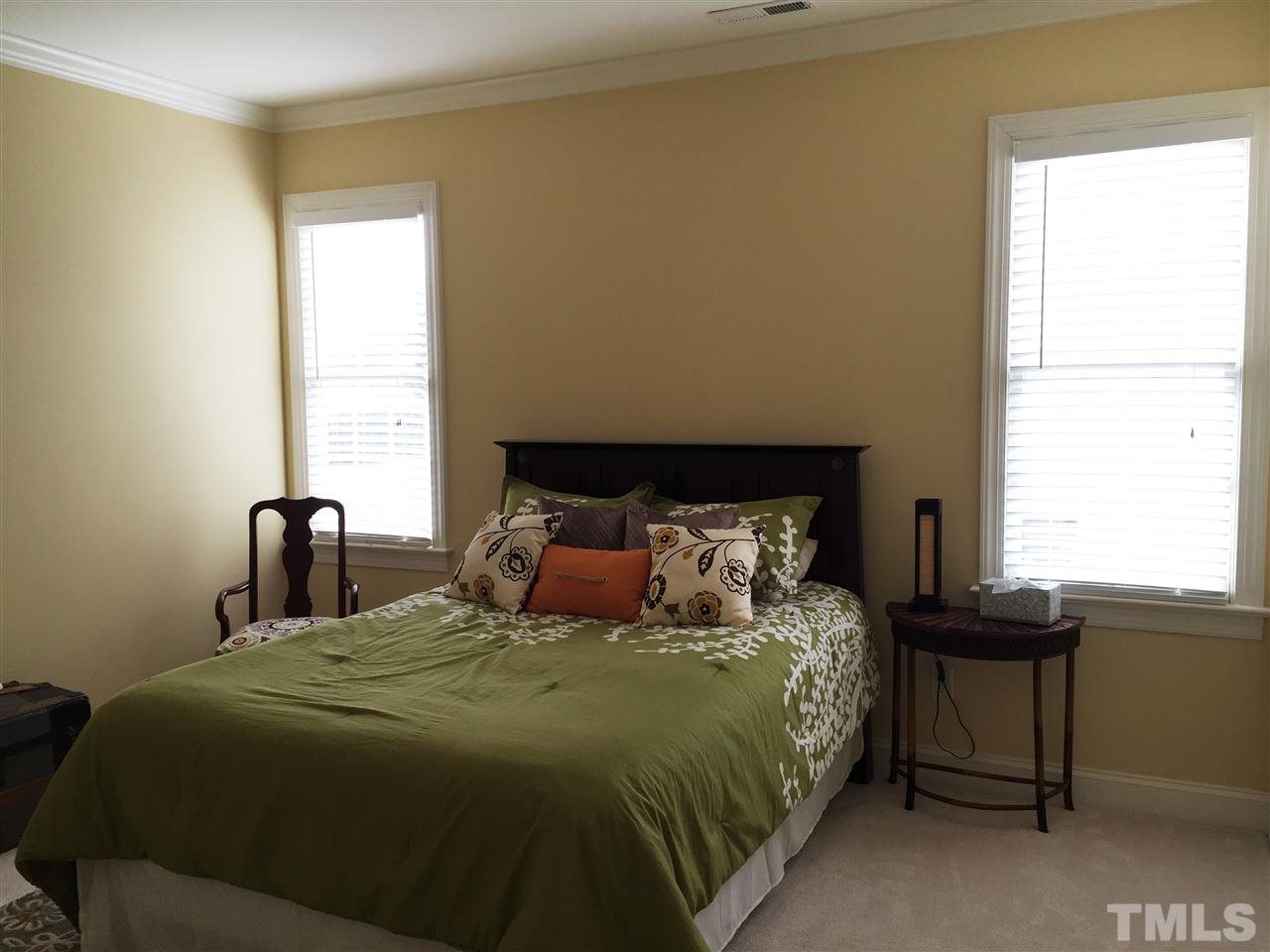 1307 Ileagnes Road Raleigh, NC 27603 - Photo 19 of 24 Bedroom 2 features crown molding, two windows, and a walk-in closet.