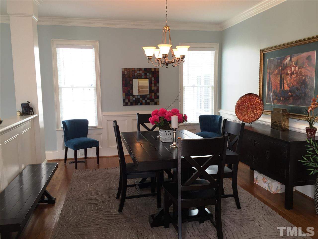 1307 Ileagnes Road Raleigh, NC 27603 - Photo 9 of 24 The dining room boasts detailed wainscoting with chair rail. Crown molding is throughout the home. Site finished hardwood floors flow from the family room, to the dining room, and into the kitchen.