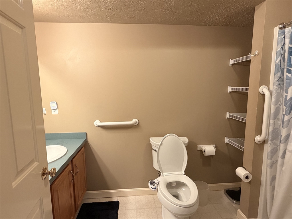 7 Conant Road, Unit 21 Winchester, MA 01890 - Photo 11 of 27 a white toilet sitting next to a bathroom sink and a mirror