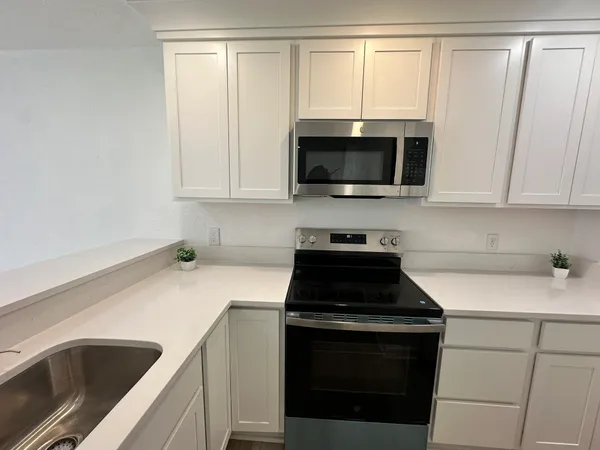 a kitchen with a sink and a stove top oven