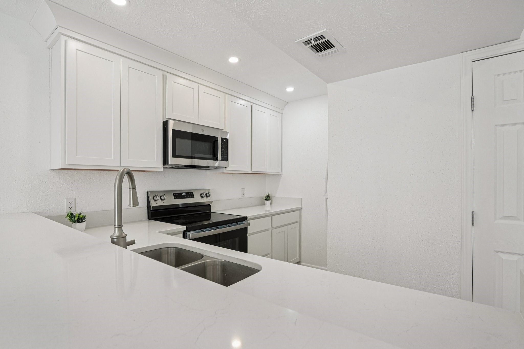 2800 Jeanetta Street, Unit 203 Houston, TX 77063 - Photo 10 of 34 a kitchen with granite countertop white cabinets and black stainless steel appliances