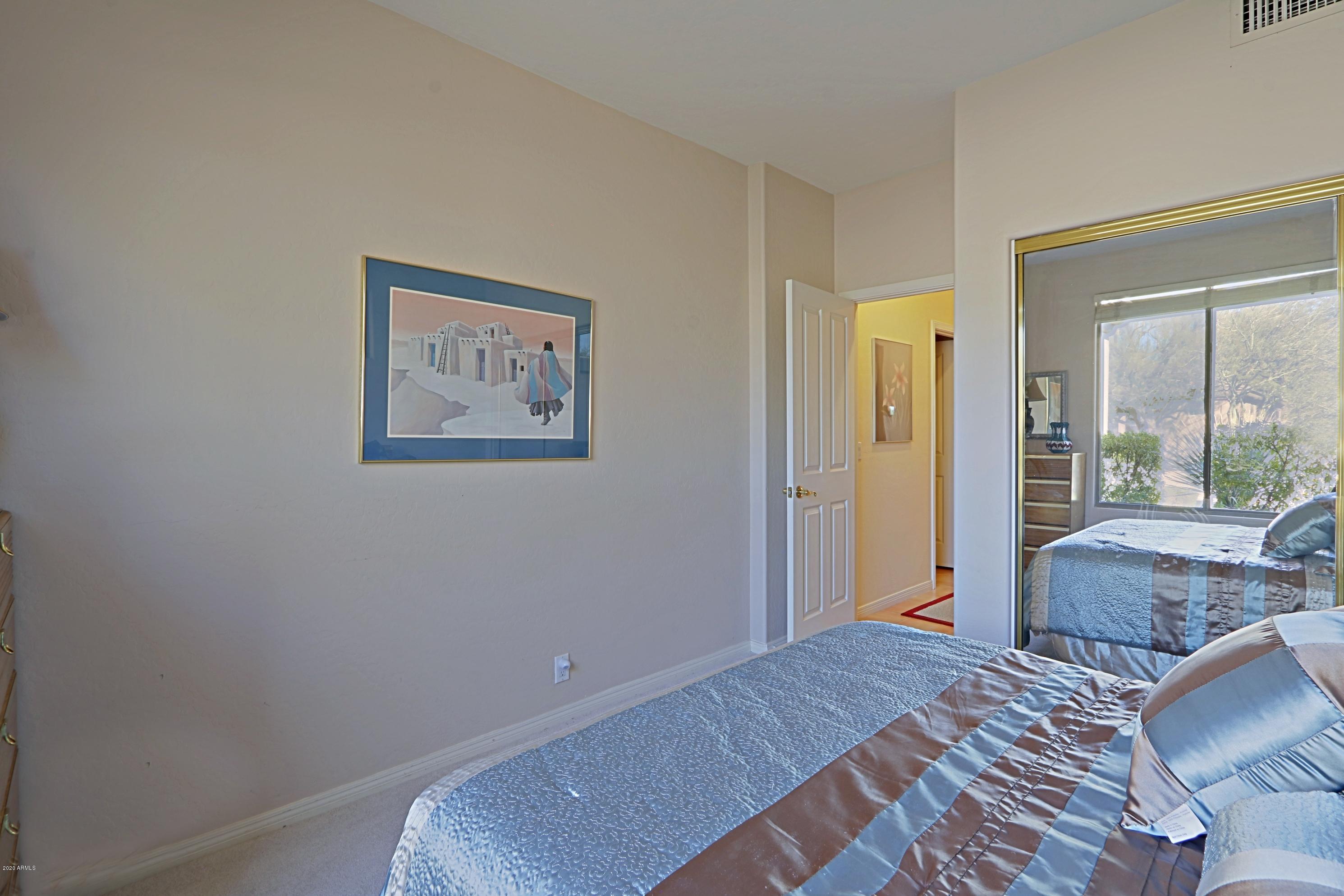 6803 East Eagle Feather Road Scottsdale, AZ 85266 - Photo 18 of 67 a bedroom with a bed and glass windows