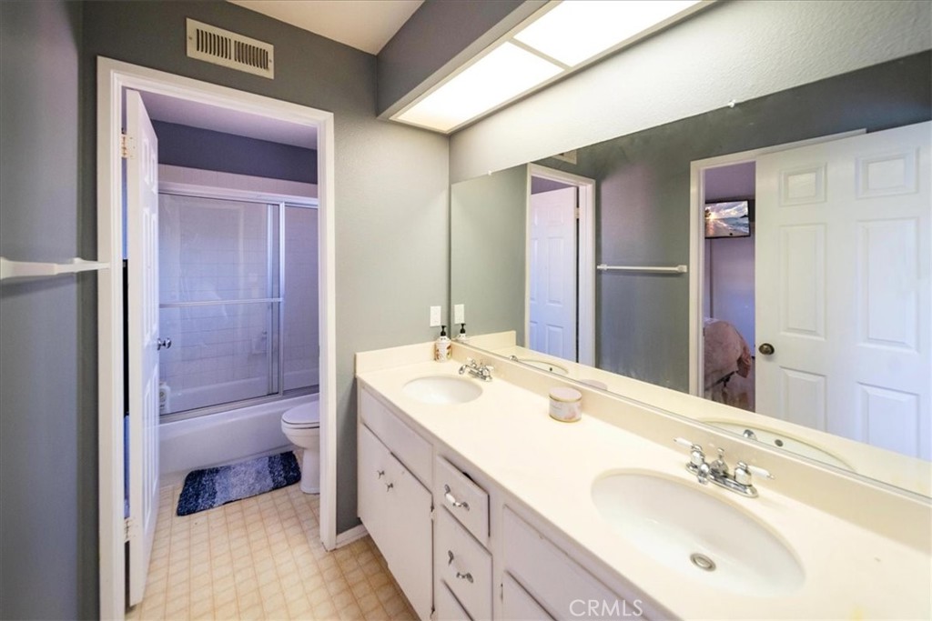 5963 Rio Valle Drive Bonsall, CA 92003 - Photo 34 of 49 a bathroom with a double vanity sink and mirror with shower