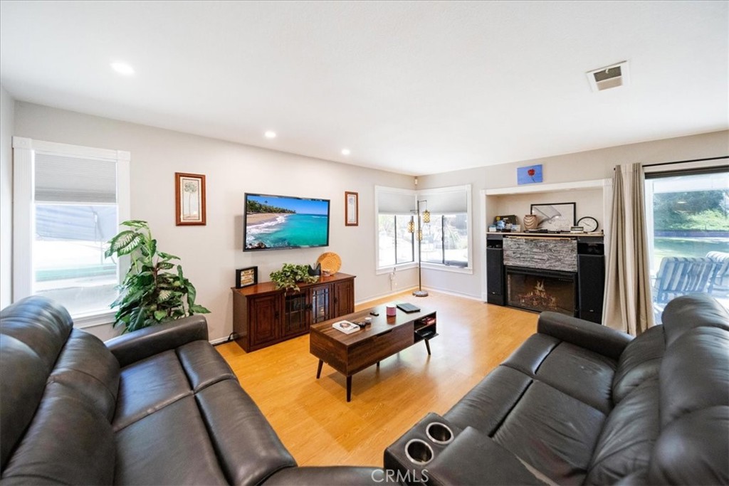 5963 Rio Valle Drive Bonsall, CA 92003 - Photo 10 of 49 a living room with furniture a flat screen tv and a fireplace