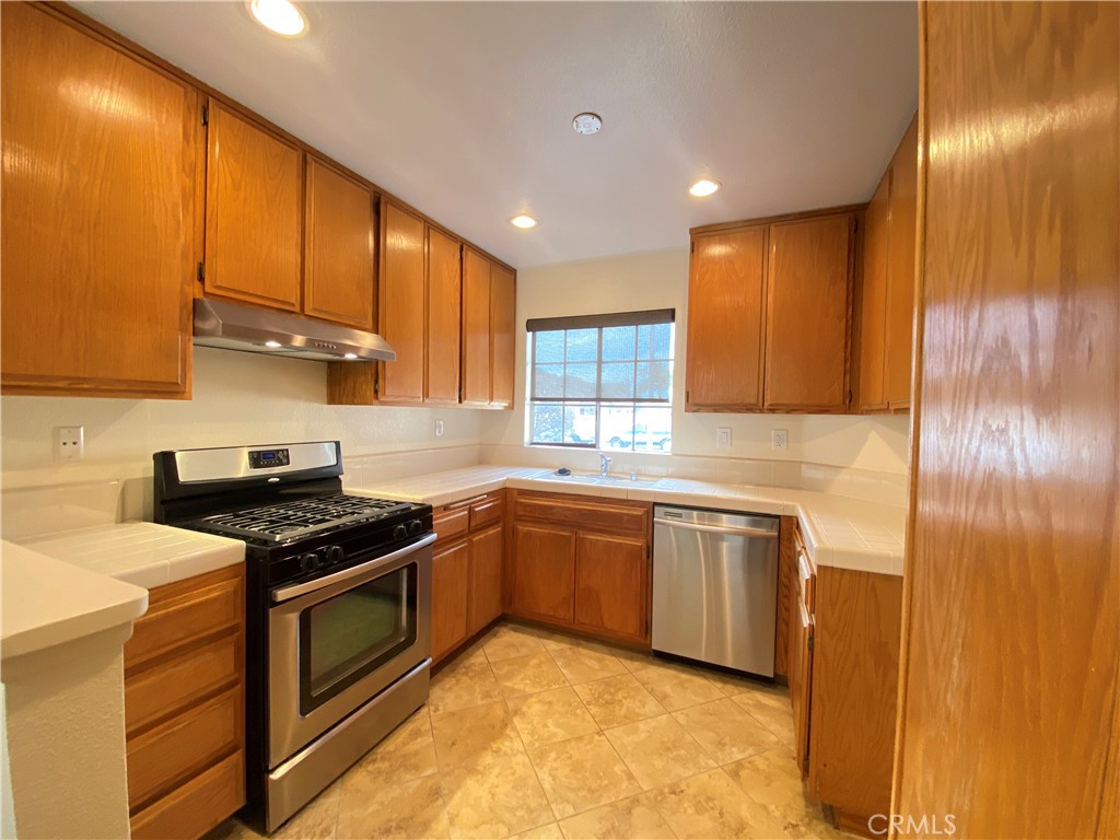 1084 North Jacaranda Road Colton, CA 92324 - Photo 5 of 19 a kitchen with stainless steel appliances granite countertop sink stove and cabinets