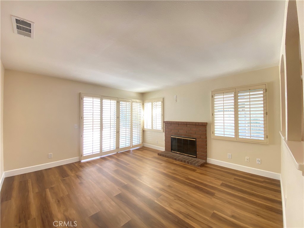 1084 North Jacaranda Road Colton, CA 92324 - Photo 8 of 19 an empty room with wooden floor fireplace and windows