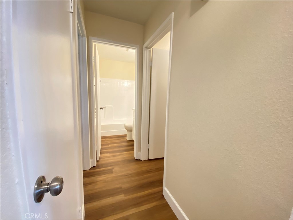 1084 North Jacaranda Road Colton, CA 92324 - Photo 9 of 19 a view of a hallway with wooden floor and a bathroom