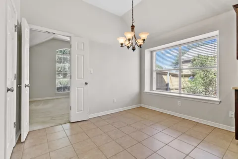 an empty room with chandelier and windows