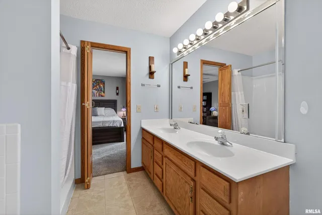 a en suite bathroom with a sink double vanity and a mirror