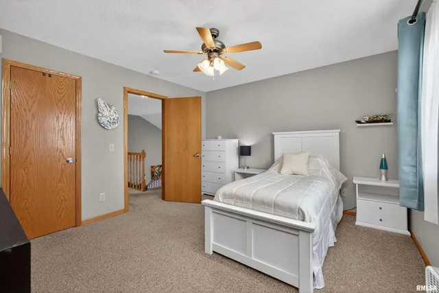 a bedroom with a bed and a ceiling fan