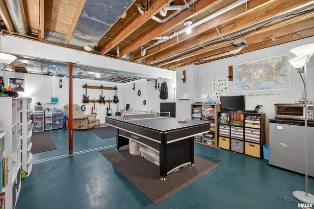 a living room with stainless steel appliances kitchen island a stove and a chandelier
