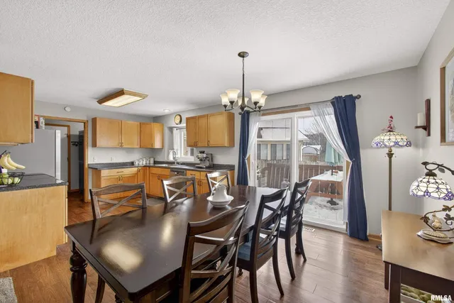 a dining room with furniture a chandelier and wooden floor
