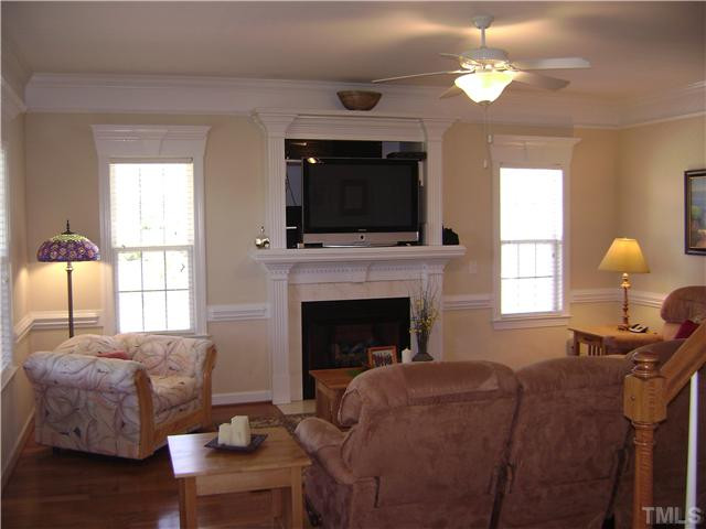 525 Winfred Drive Raleigh, NC 27603 - Photo 6 of 25 Living room with gorgeous hardwood floors, gas log fireplace with custom mantle & entertainment niche, heavy crown, chair and window moldings! Living Room