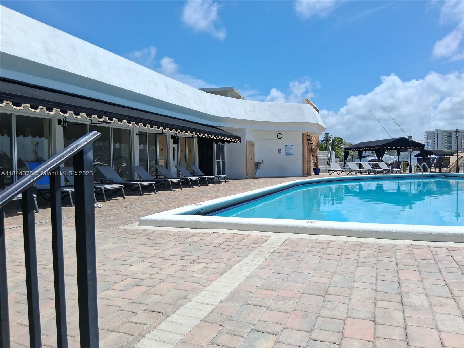 100 Golden Isles Drive, Unit 206 Hallandale Beach, FL 33009 - Photo 11 of 22 a view of swimming pool with seating space