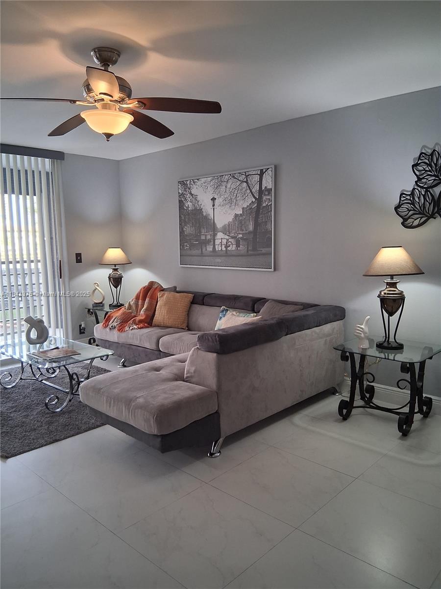 100 Golden Isles Drive, Unit 206 Hallandale Beach, FL 33009 - Photo 17 of 22 a living room with furniture and a chandelier