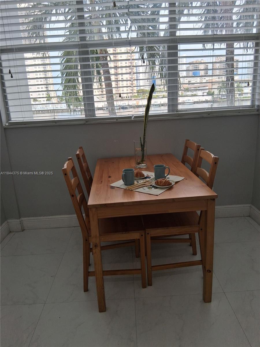100 Golden Isles Drive, Unit 206 Hallandale Beach, FL 33009 - Photo 19 of 22 a dining room with furniture and window