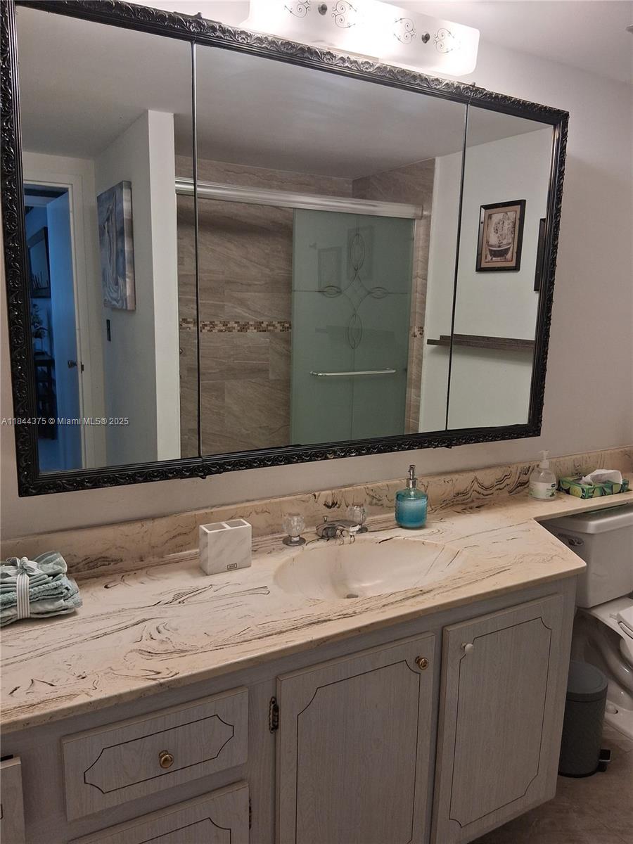 100 Golden Isles Drive, Unit 206 Hallandale Beach, FL 33009 - Photo 22 of 22 a bathroom with a sink and a mirror