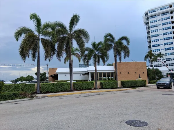 a front view of multiple house with palm trees