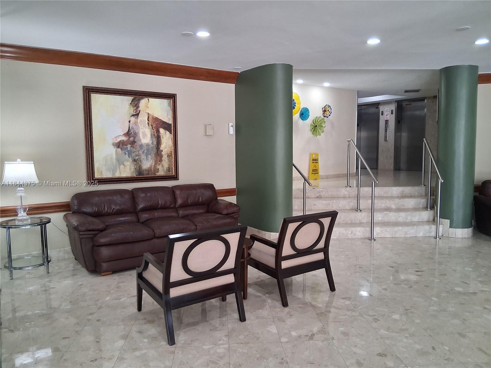 100 Golden Isles Drive, Unit 206 Hallandale Beach, FL 33009 - Photo 4 of 22 a living room with furniture and a painting on the wall