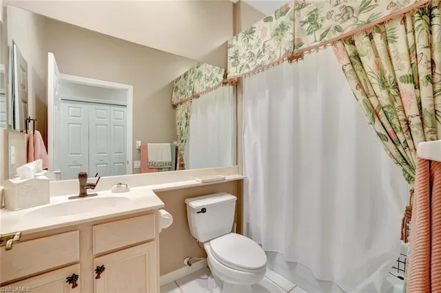 a bathroom with a sink a toilet a mirror and shower curtain