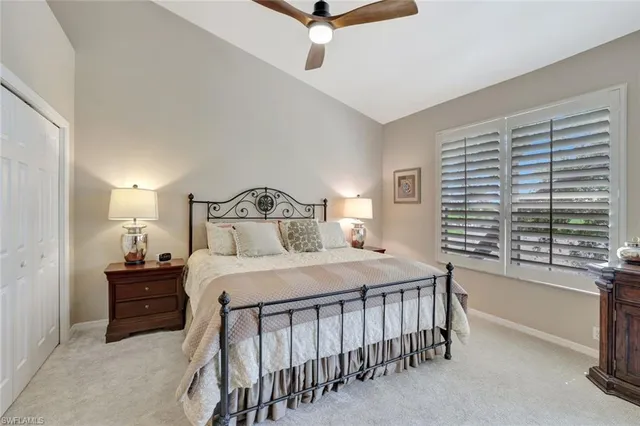 a bedroom with a bed next to a large window